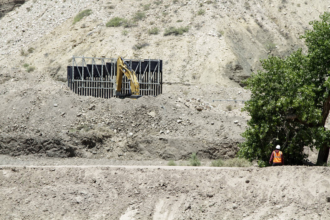 In a May 24, 2019 photo, a construction worker watches a section of fencing be moved for a priv ...