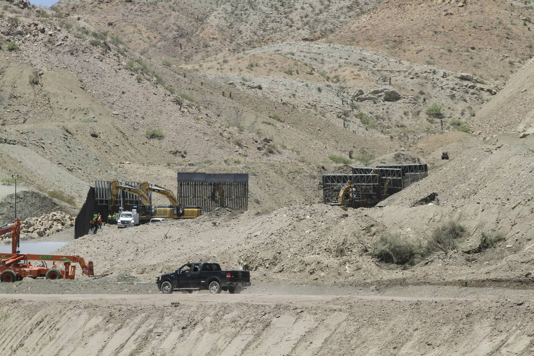 In a May 25, 2019 photo, construction workers install sections of fencing for a privately-funde ...