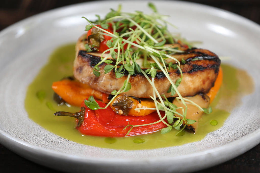 The swordfish is served with hot and sweet marinated peppers, grilled zucchini and sorrel, at t ...