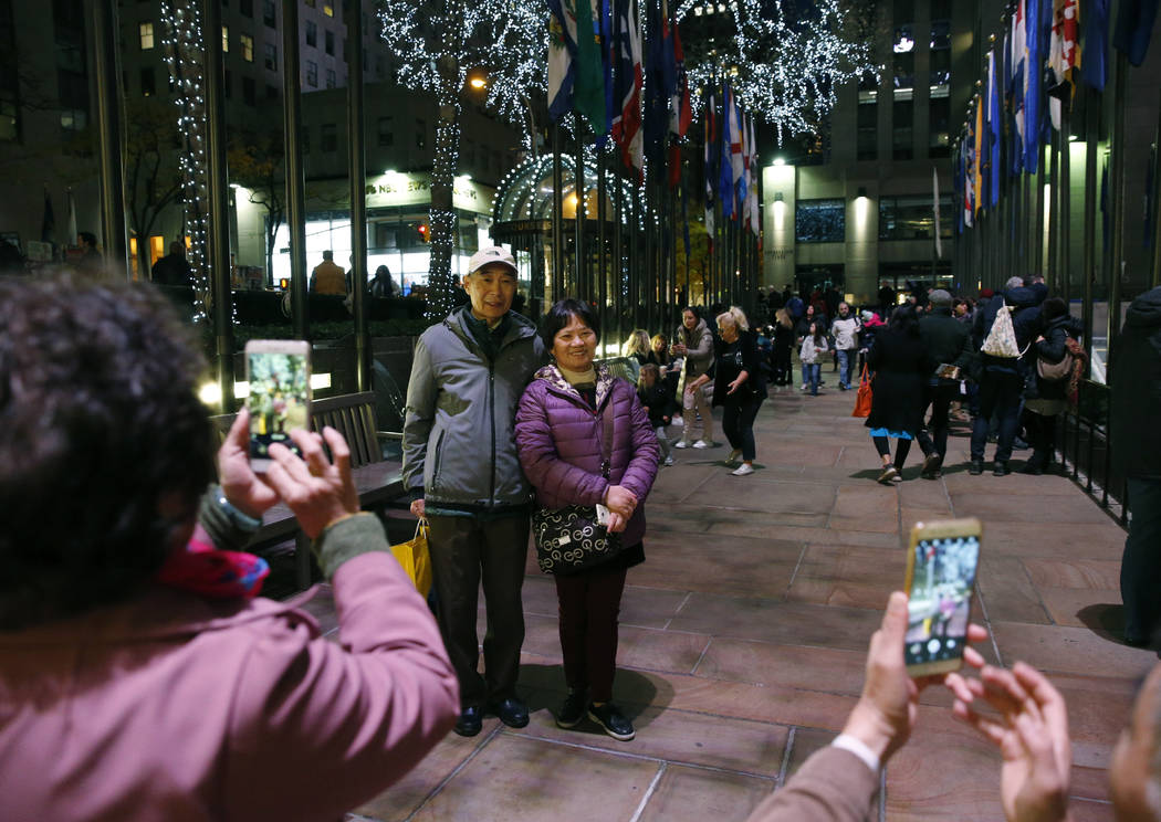 FILE - In this Nov. 12, 2017, file photo tourists from China pose for photographs at Rockefelle ...