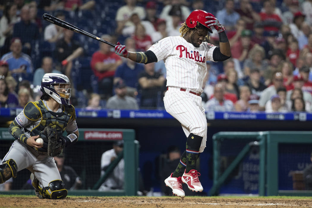 Philadelphia Phillies' Odubel Herrera holds onto his helmet on the swing during the sixth innin ...