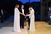 U.S. President Donald Trump, center left, and First lady Melania Trump, front left, are greeted ...