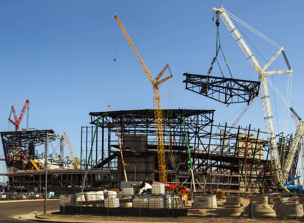 The newest truss is slowly lowered and attached into place at the top of Raiders Las Vegas Stad ...