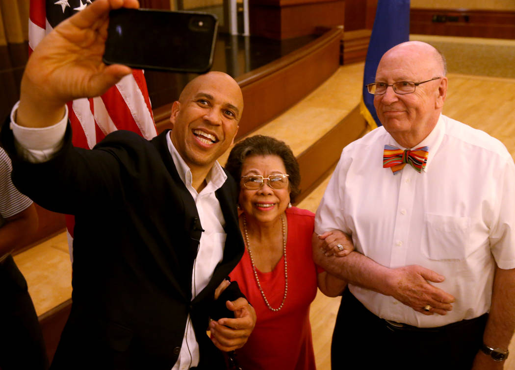 Presidential hopeful Sen. Cory Booker, D-N.J., takes a selfie with Cristina and Ed Drost of Hen ...