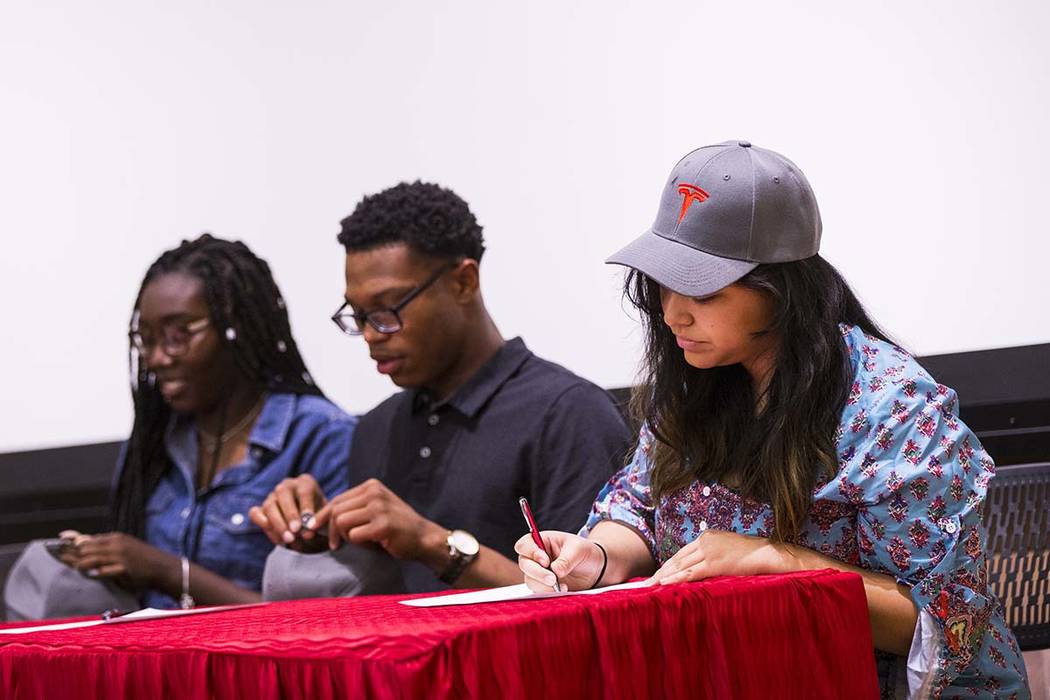 Savannah Mantanona, of Basic High School, right, signs paperwork during a ceremony for high sch ...