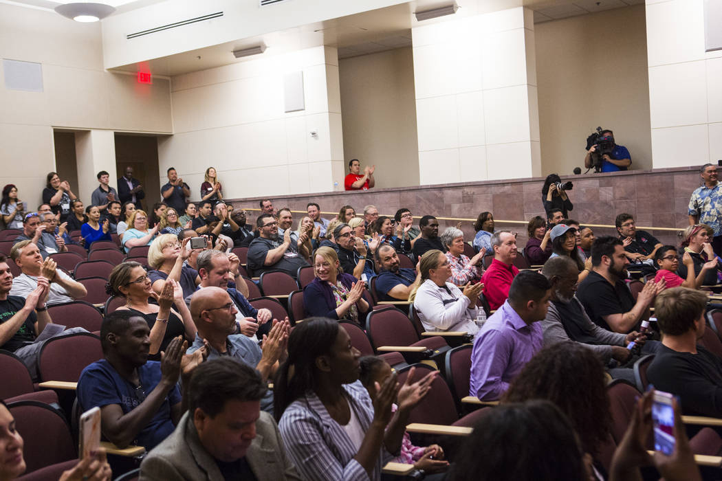 Attendees cheer during a signing ceremony for recent high school graduates that were hired by T ...