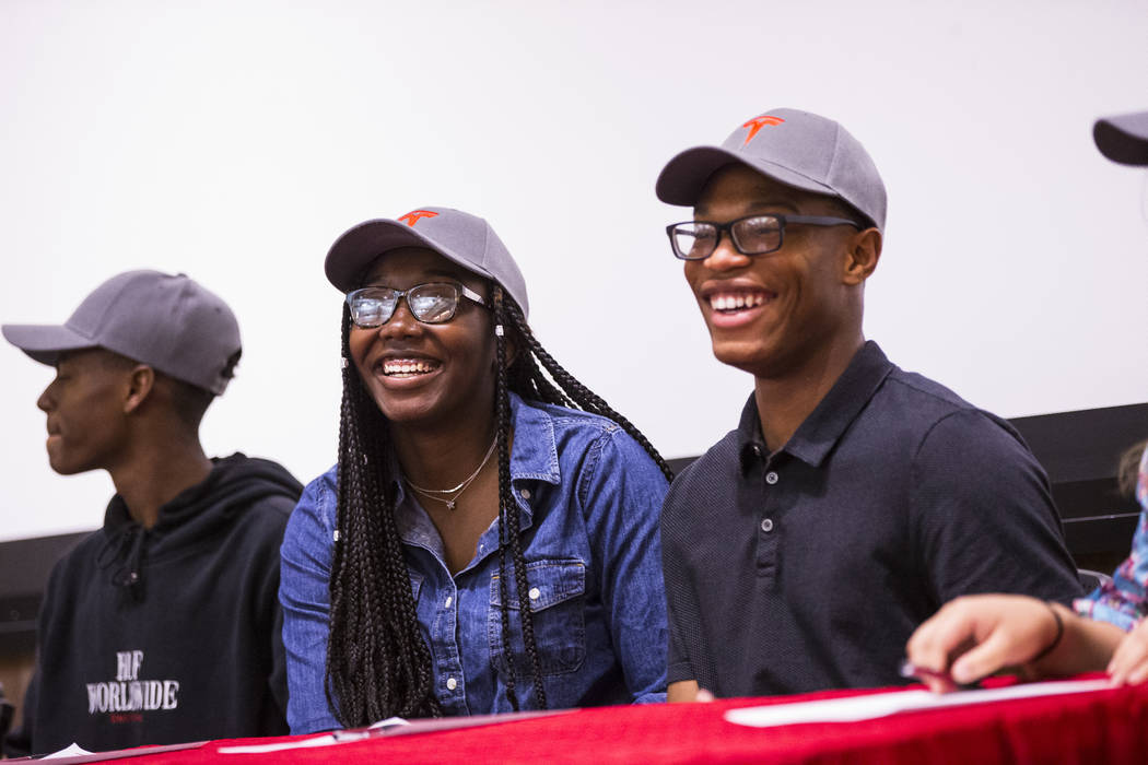 Centennial graduates DeRajanique McKinney, center left, and Jayquan Jackson, right, react durin ...