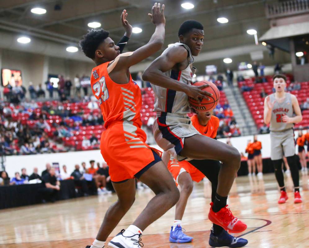 Findlay Prep's Alex Tchikou, right, moves the ball around Bishop Gorman's Mwani Wilkinson (23) ...