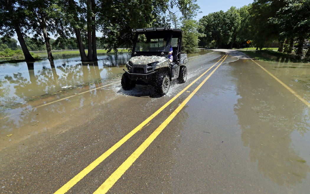 In this Thursday, May 23, 2019 photo, a Holly Bluff, Miss., resident drives through backwater f ...