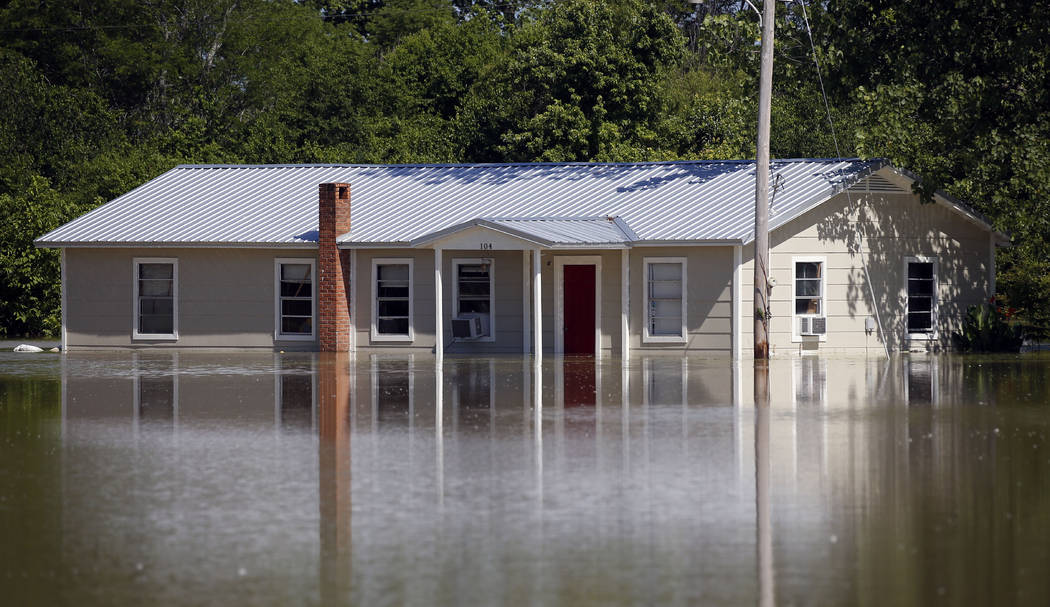 In this Thursday, May 23, 2019 photo, floodwaters overtake a home in Holly Bluff, Miss. It&#x20 ...