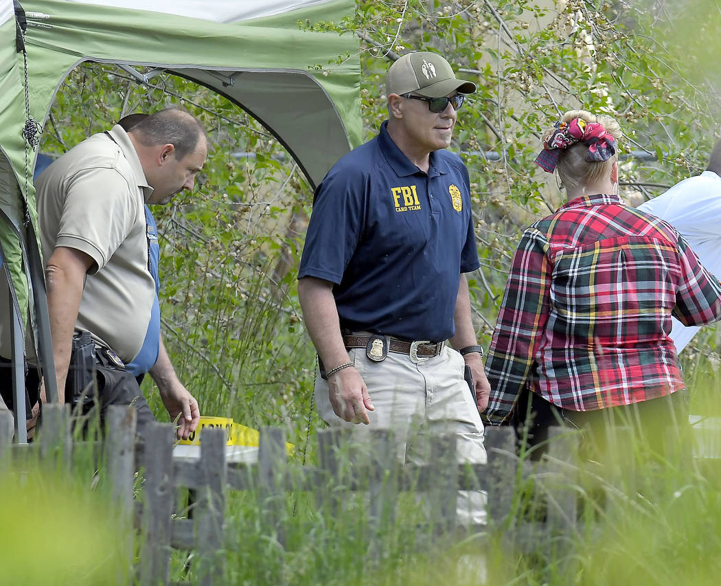 Law enforcement investigate the scene where a body that they believe to be Elizabeth Shelley wa ...