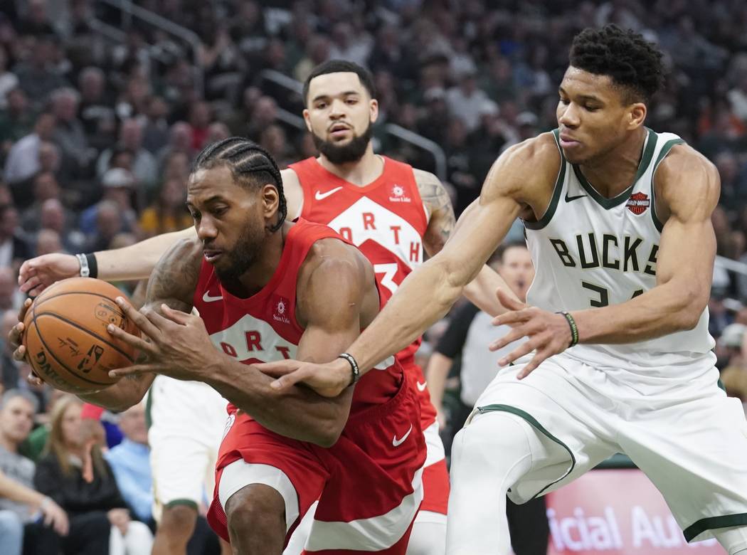 Milwaukee Bucks' Giannis Antetokounmpo and Toronto Raptors' Kawhi Leonard go after a loose ball ...