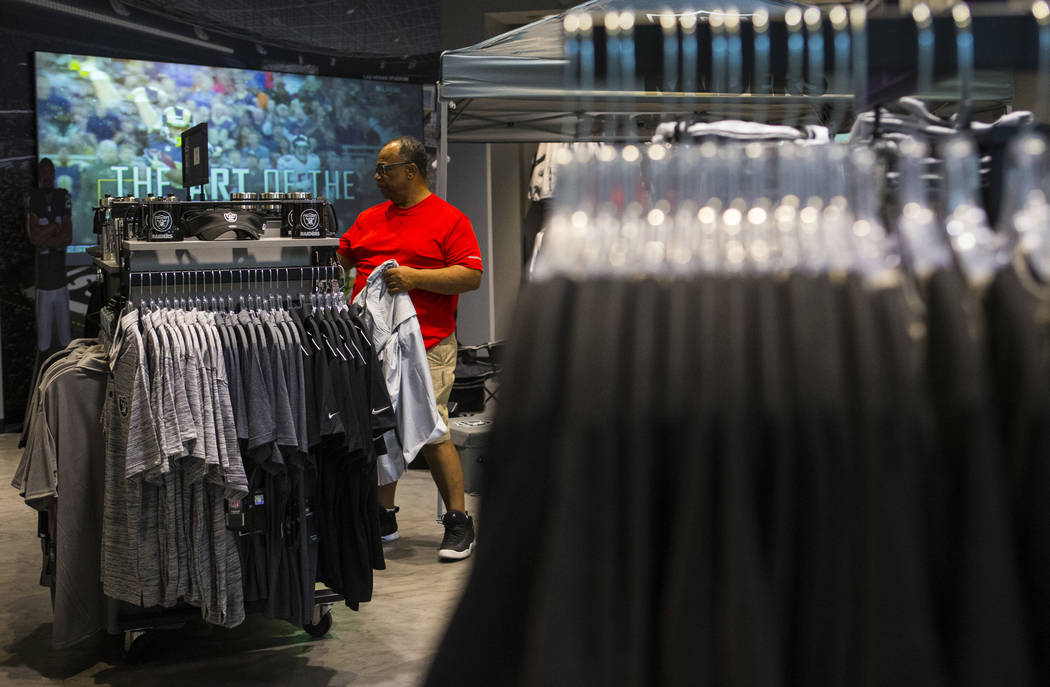 BJ Freeman, of Texas, looks through shirts and jerseys at The Raider Image store at the Galleri ...