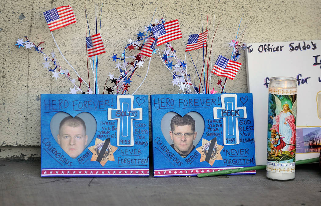 Candles, flags and other items sit at a makeshift memorial near the front door of Cicis Pizza a ...