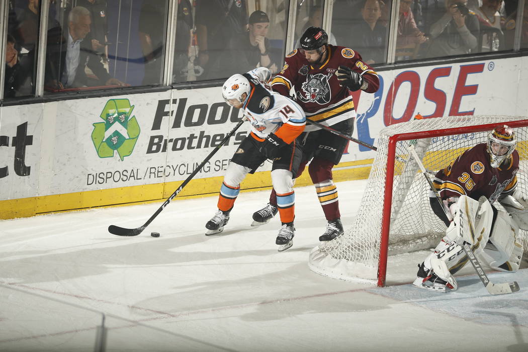 Chicago Wolves defenseman Nic Hague (2) tangles with San Diego Gulls center Kalle Kossila behin ...