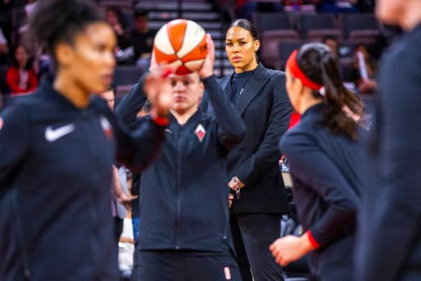 Las Vegas Aces center Liz Cambage (wearing street clothes) watches her teammates warm up before ...