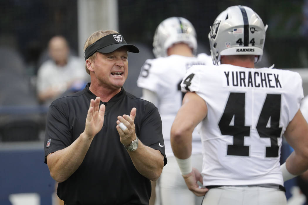 Oakland Raiders head coach Jon Gruden calls to his team as he stands next to running back Ryan ...