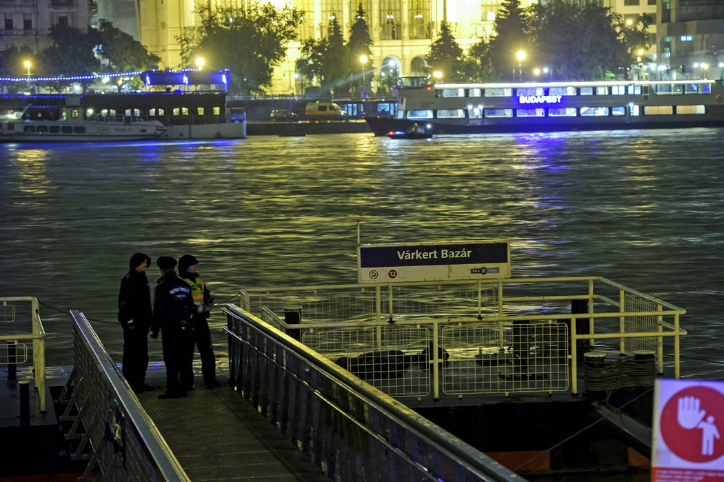 Police officers stand on a landing dock early Thursday, May 30, 2019 after a tourist boat crash ...