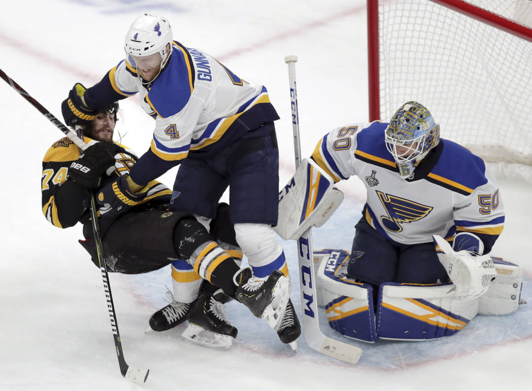 St. Louis Blues' Carl Gunnarsson (4), of Sweden, checks Boston Bruins' Jake DeBrusk (74) to the ...