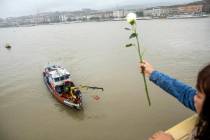 A woman throws a flower from the Margaret Bridge during a search operation on the River Danube ...