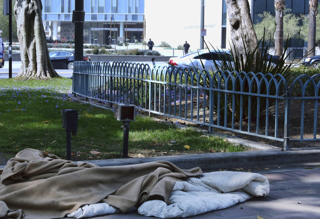 An abandoned sleeping bag and blanket is left in on the grounds of Los Angeles City Hall across ...