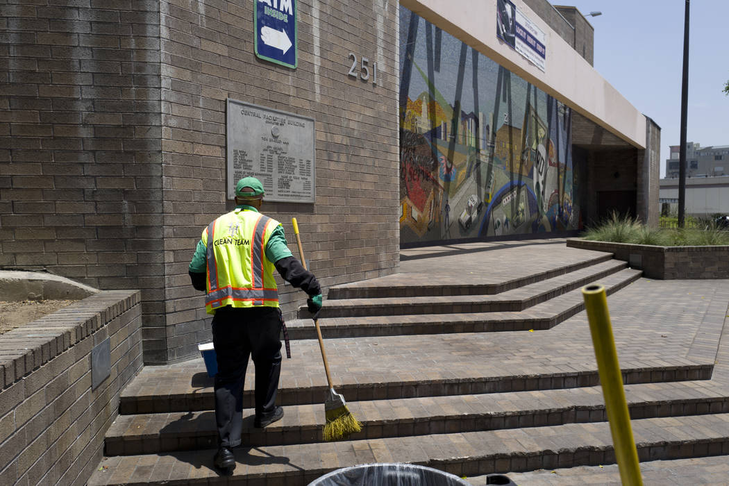 A cleaning crew sweeps up in front of LAPD Central Community Police Station in downtown Los Ang ...