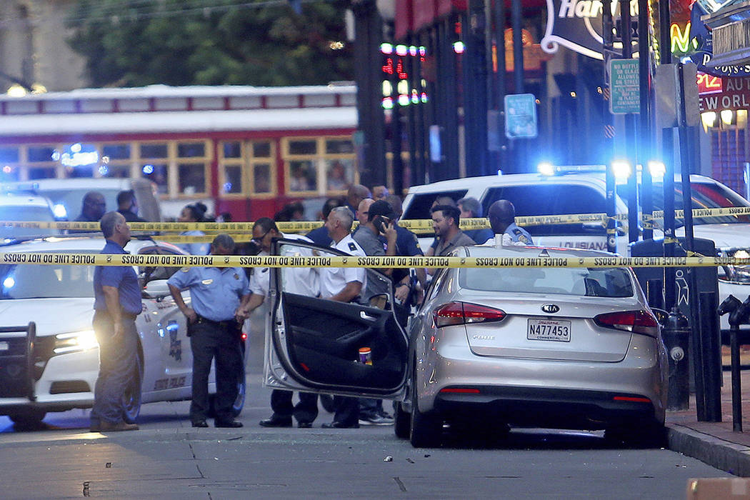 Investigators look at a Kia Forte with a shattered driver's window after a Louisiana state troo ...