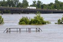 Traffic moves over the I-540 bridge as the Arkansas River floods along Adams Street Thursday, M ...