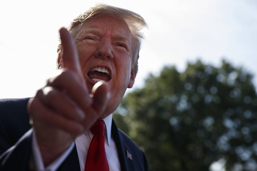 President Donald Trump talks with reporters before departing on Marine One for the Air Force Ac ...