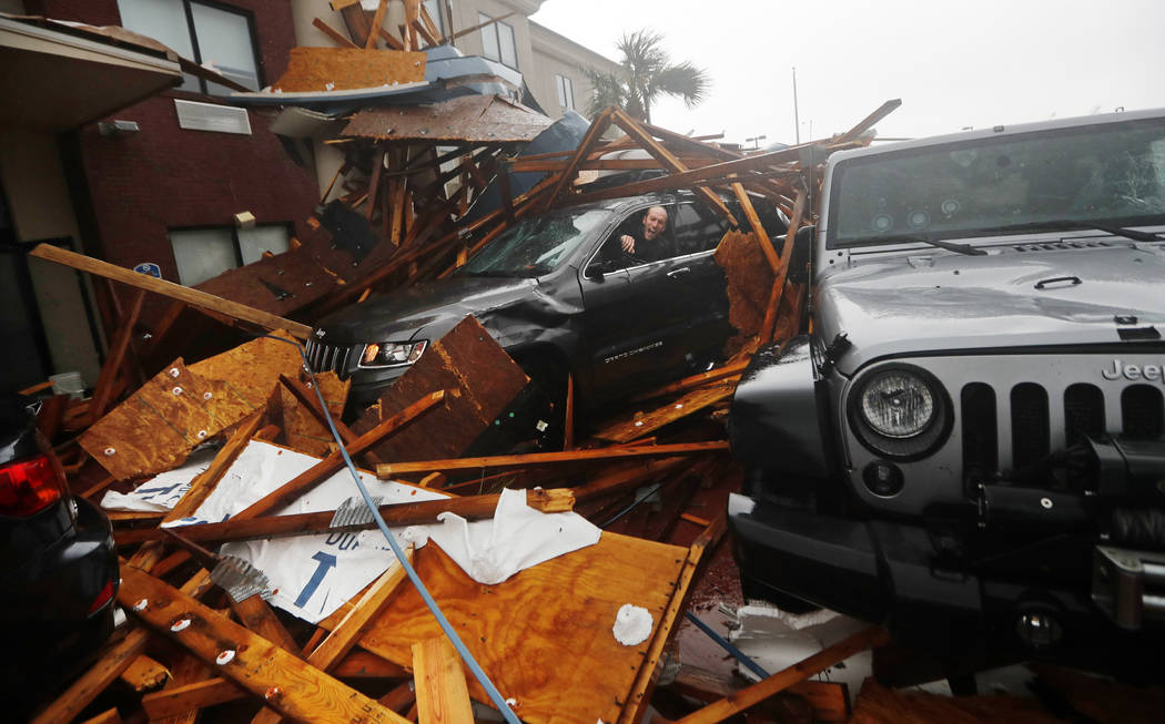 FILE - In this Oct. 10, 2018, file photo, a storm chaser climbs into his vehicle to retrieve eq ...