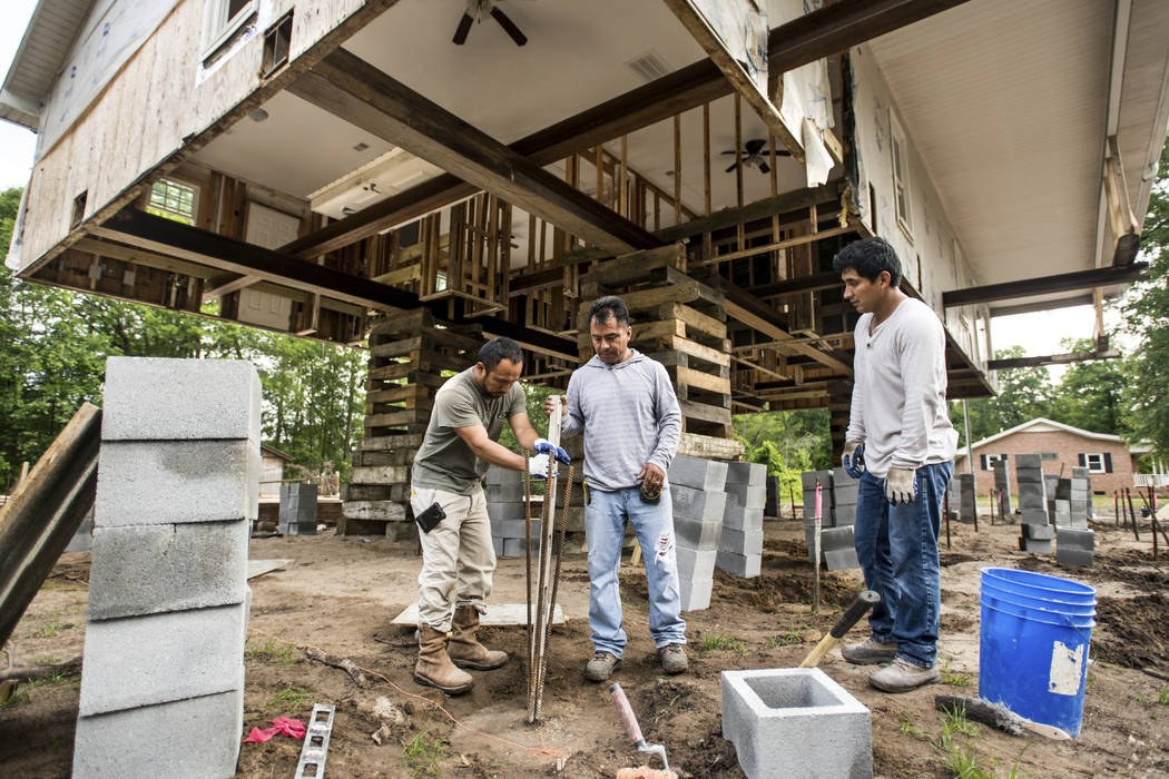 In this May 13, 2019, photo, construction workers prepares rebar used to raise a house near the ...