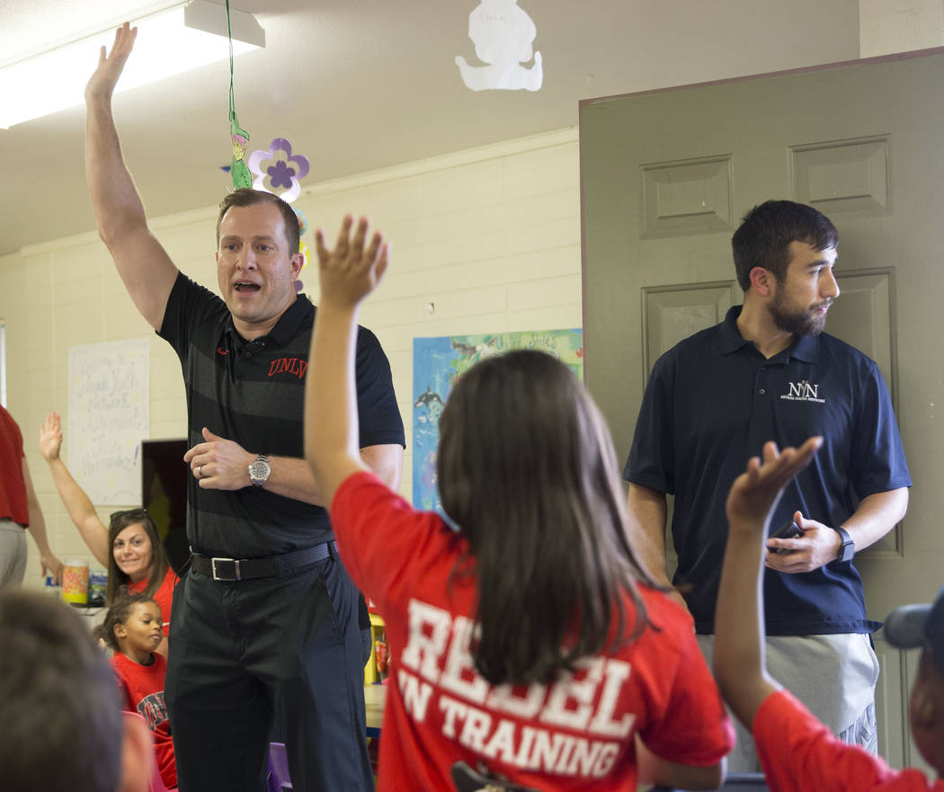 UNLV head basketball coach T.J. Otzelberger, left, answers questions from children during a you ...