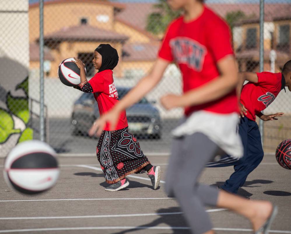 Fardosa Blial, left, 6, dribbles a basketball during a youth clinic hosted by UNLV head basketb ...