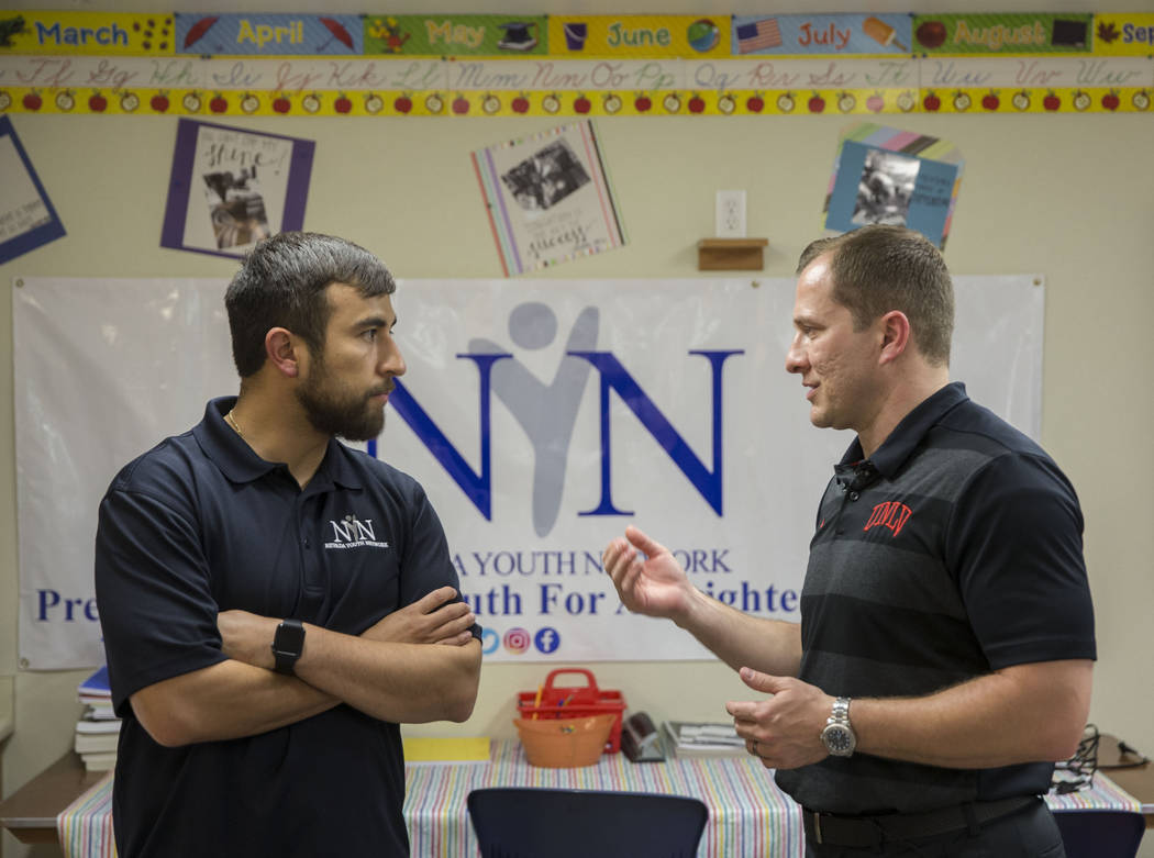 UNLV head basketball coach T.J. Otzelberger, right, speaks with Nevada Youth Network founder Mi ...