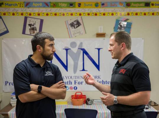 UNLV head basketball coach T.J. Otzelberger, right, speaks with Nevada Youth Network founder Mi ...
