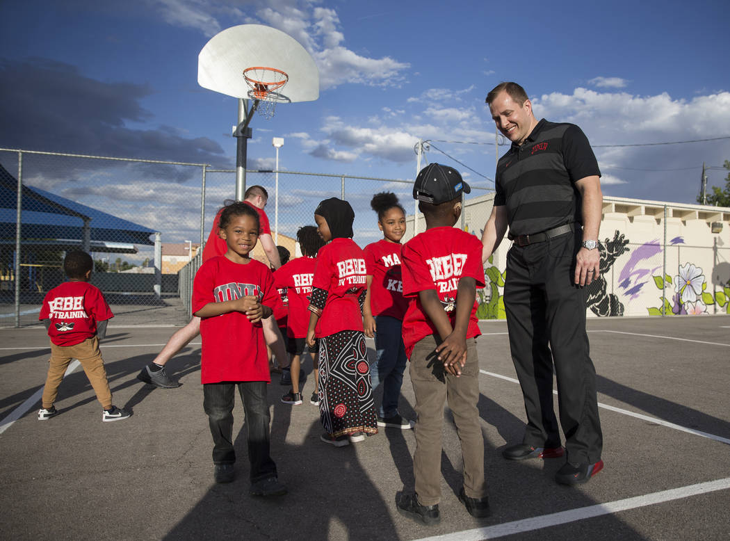UNLV head basketball coach T.J. Otzelberger, right, talks with kids during a youth clinic at th ...
