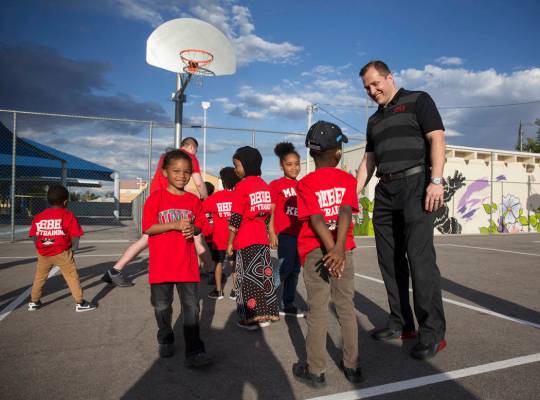 UNLV head basketball coach T.J. Otzelberger, right, talks with kids during a youth clinic at th ...