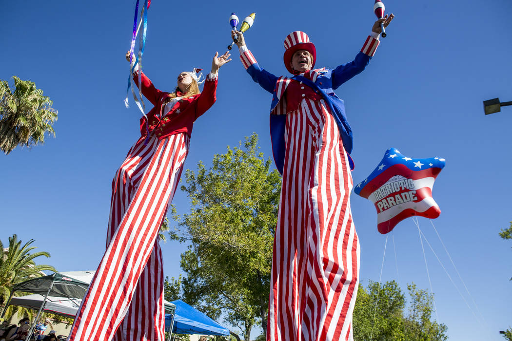 Patriotic stilt walkers wave to crowds during the Summerlin Council Patriotic Parade in Summerl ...