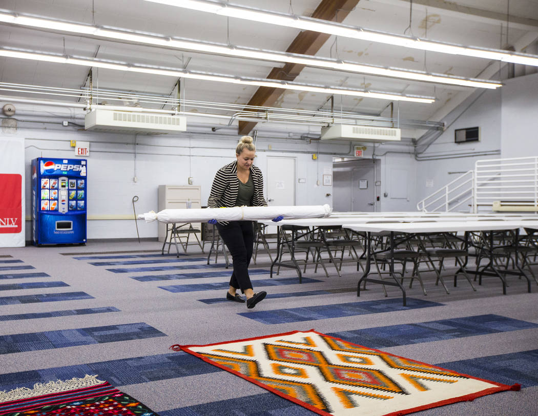 Doctoral student Paige Figanbaum moves rugs and other items from Walking Box Ranch, in Searchli ...