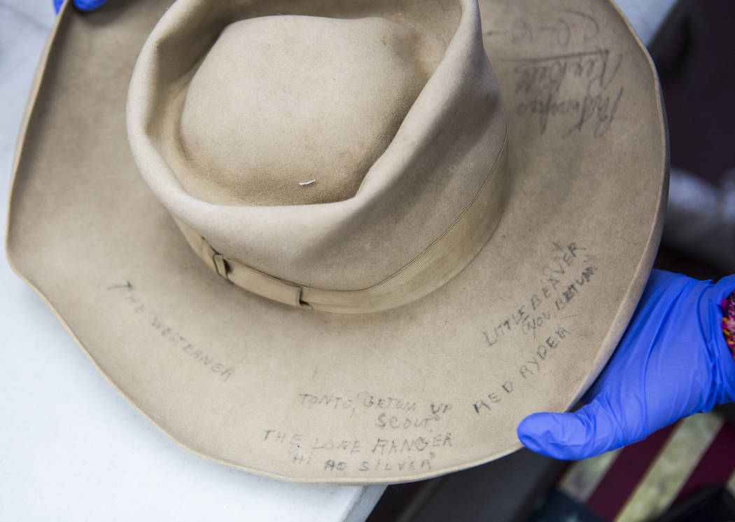 Senior history student Kassidy Whetstone examines a cowboy hat with written markings referencin ...