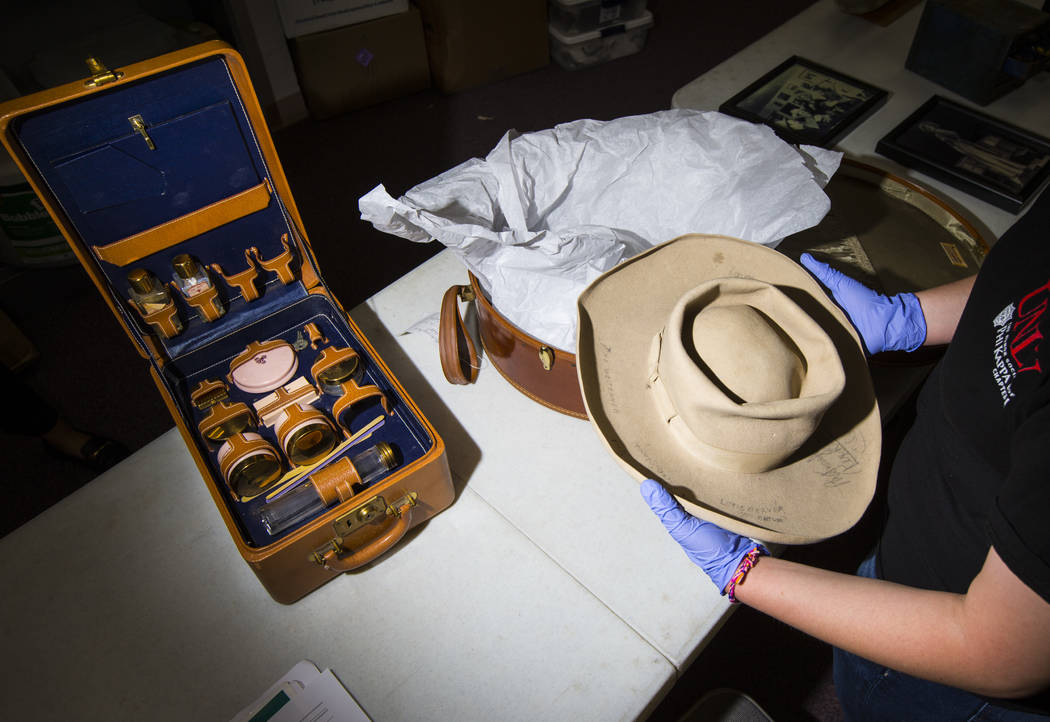 Senior history student Kassidy Whetstone examines a cowboy hat with written markings referencin ...