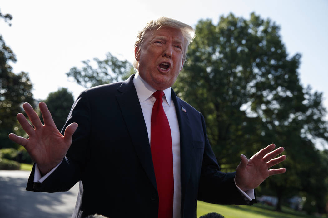 President Donald Trump talks with reporters before departing on Marine One for the Air Force Ac ...