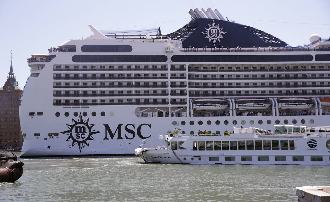 The MSC Magnifica cruise ship passes by the tourist boat, foreground, bottom right, that was st ...