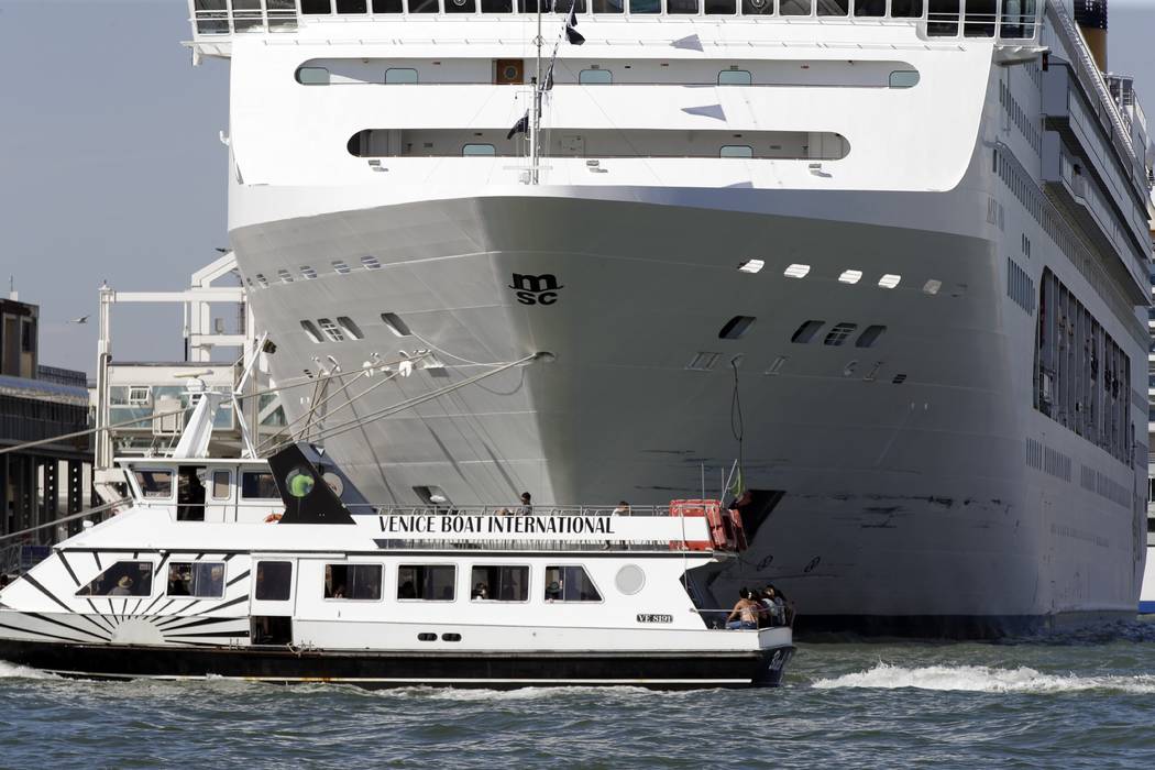 A boat passes by the MSC Opera cruise ship moored at the Venice harbor, Italy, Sunday, June 2, ...