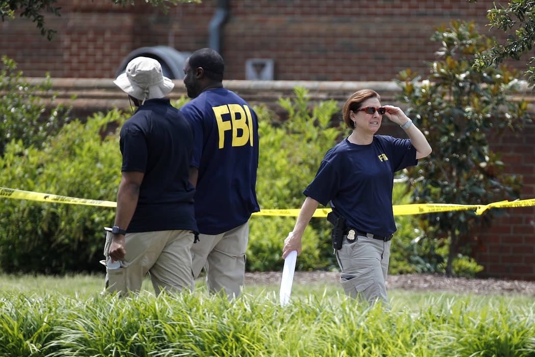 Law enforcement officials work outside a municipal building that was the scene of a shooting, S ...