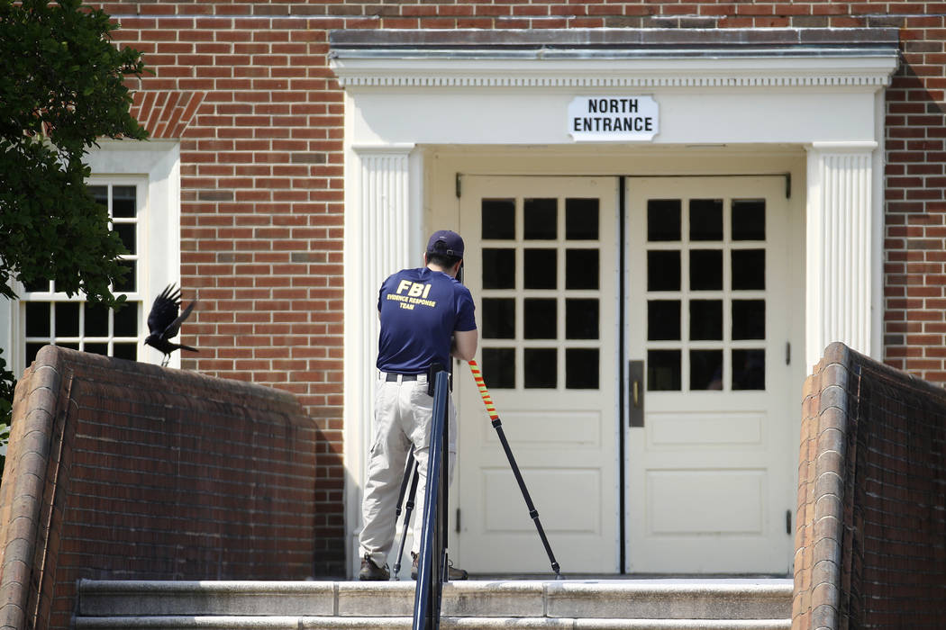 A member of the FBI works outside an entrance to a municipal building that was the scene of a s ...