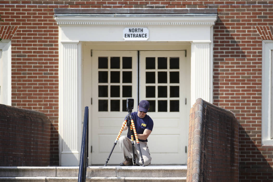 A member of the FBI works outside an entrance to a municipal building that was the scene of a s ...