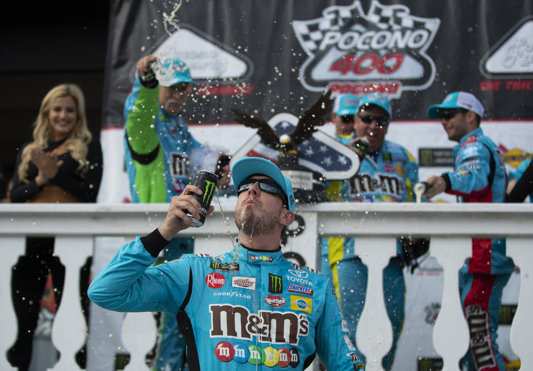 Kyle Busch celebrates in victory lane after winning a NASCAR Cup Series auto race at Pocono Rac ...