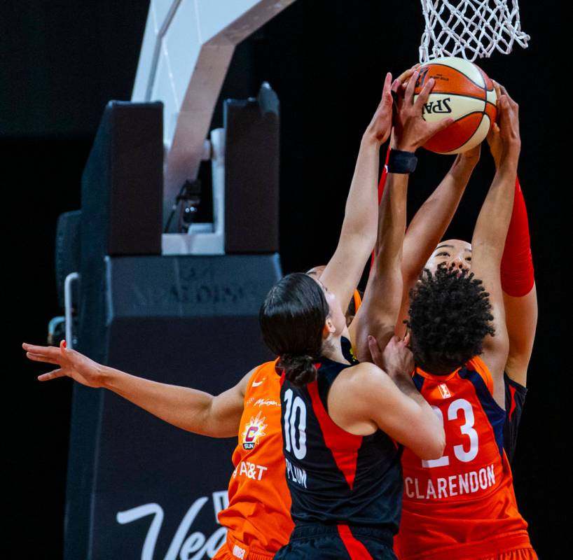 Las Vegas Aces guard Kelsey Plum (10) and teammate center Ji-Su Park (19) team up to take a reb ...