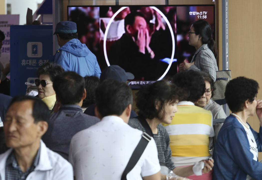 People watch a TV screen showing an image of senior North Korean official Kim Yong Chol in a mu ...